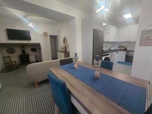 a living room with a wooden table and a kitchen at Villa Mares in Casas Novas de Marés