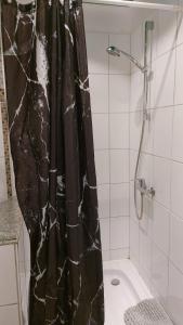 a bathroom with a shower with a black shower curtain at FineApartment Rendsburg in Rendsburg