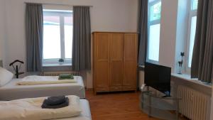 a living room with two beds and a television at FineApartment Rendsburg in Rendsburg