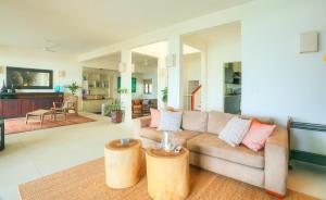 a living room with a couch and two wooden stools at Peter's Beach House in Poste Lafayette