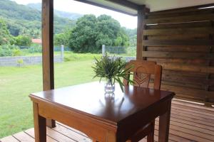 a wooden table with a vase on it on a porch at Moorea Lodge Arii in Afareaitu