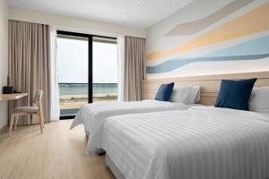 two beds in a hotel room with a view of the ocean at BTP Hotel Nakhon Phanom in Ban Noi Pho Kham +29 photos