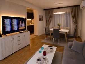 a living room with a couch and a tv and a table at AS Apartment Tetovo in Tetovo