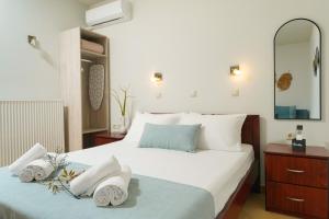 a bedroom with a large bed with towels on it at Porto Nuovo Studio 2 in Limenas