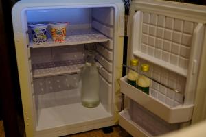 an open refrigerator with a bottle of water in it at Eryri Golden Stays in Capel Garmon