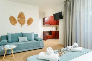 a living room with a blue couch and a kitchen at Porto Nuovo Studio 2 in Limenas