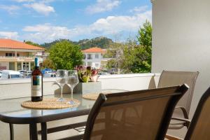 a table with a bottle of wine and glasses on a balcony at Porto Nuovo Studio 2 in Limenas