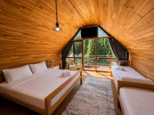 a bedroom with two beds and a large window at Kolsay Tanbalytas A-Frame in Kolʼbastau