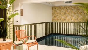 a room with a chair and a swimming pool at Hôtel Lepoussin in Cannes