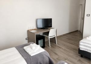 a bedroom with a desk with a tv and a chair at Regia Hotel in Abbasanta