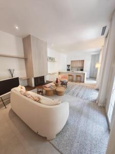 a living room with a white couch and a kitchen at La Maison Cannoise in Cannes