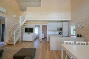 a kitchen and living room with a staircase in a house at Villa Arvonpiha A in Tahkovuori