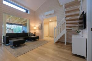 a living room with a couch and a staircase at Villa Arvonpiha A in Tahkovuori