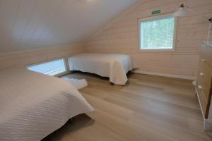 two beds in a small room with a window at Villa Arvonpiha A in Tahkovuori