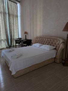 a large bed in a bedroom with a desk and window at Sea Cloud Hotel in Zatoka