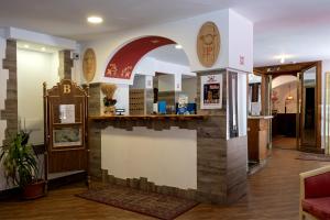 una hall di ristorante con un bancone e un arco di Hotel Posta R.T.A. a Madonna di Campiglio