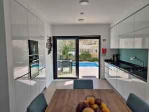 a kitchen and dining room with a table with fruit at Casa Encanto da Foz - BY SCH in Foz do Arelho