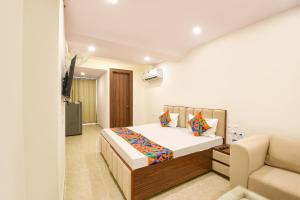 a bedroom with a bed and a couch at FabHotel Durga Luxury Studio in Gurgaon