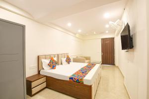 a bedroom with a bed and a flat screen tv at FabHotel Durga Luxury Studio in Gurgaon +26 photos