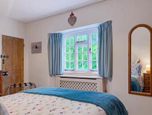 a bedroom with a bed and a window at Ruffles Cottage Dunster in Dunster