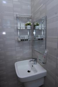 a white bathroom with a sink and a mirror at JJC BNB Mbweni in Bunju +21 photos