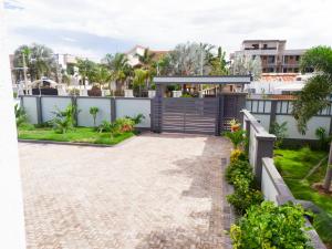 a view of a house with a gate and a walkway at JJC BNB Mbweni in Bunju