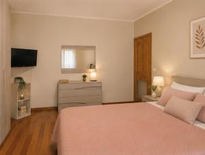 a bedroom with a bed and a dresser and a television at In Piazza Pompeii in Pompei