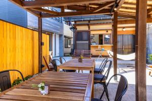 an outdoor patio with a wooden table and chairs at UG HOSTEL Takayama in Takayama