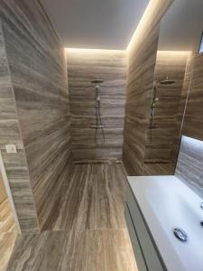 a bathroom with a tub and a shower with wooden walls at La Maison Cannoise in Cannes +6 photos