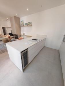 a white kitchen with a white island in a room at La Maison Cannoise in Cannes