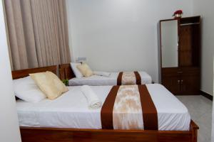 a bedroom with two beds and a mirror at JJC BNB Mbweni in Bunju