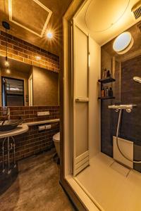 a bathroom with a shower and a toilet and a sink at UG HOSTEL Takayama in Takayama