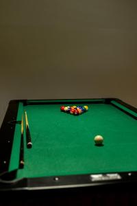 a green pool table with a cue ball and balls at Szept Beskidów in Milówka +3 photos