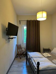 a bedroom with a bed and a flat screen tv at Dvali in Tbilisi City