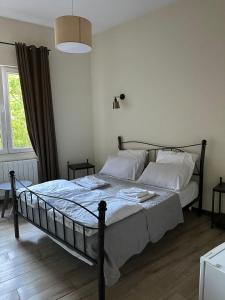 a bedroom with a bed with white sheets and a window at Dvali in Tbilisi City