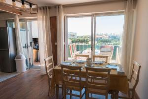 a dining room with a table and a large window at Le Lydia - Duplex - Vue Mer - Accès direct Plage - Parking - Barbecue in Le Barcarès +32 photos