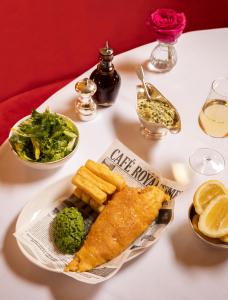 a white table with a plate of fish and vegetables at Hotel Cafe Royal in London