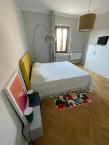 a bedroom with a white bed and a rug at Appartamento ai piedi del Borgo in Certaldo