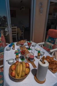 a table with bananas apples and other food on it at Le Lydia - Duplex - Vue Mer - Accès direct Plage - Parking - Barbecue in Le Barcarès