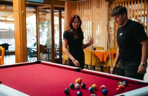 two people standing next to a pool table at Hotel Korona in Siófok
