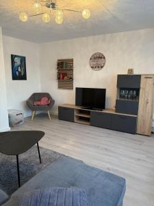 a living room with a television and a chair at Manni's Home in Munderkingen