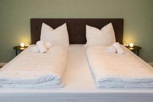 a bed with white sheets and pillows on it at Manni's Home in Munderkingen