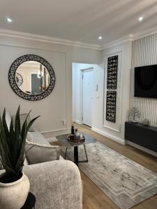 a living room with a couch and a mirror at Silver Apartment in Rădăuţi