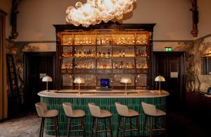 a bar with chairs and a counter with liquor bottles at Dalhousie Castle in Bonnyrigg