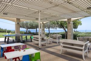 a patio with tables and chairs under a pergola at Carme Villas in Adelianos Kampos +55 photos