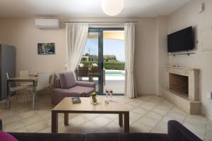 a living room with a couch and a table and a fireplace at Carme Villas in Adelianos Kampos