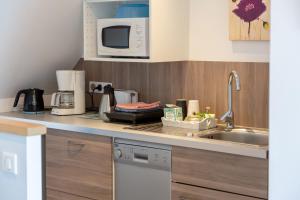a kitchen with a sink and a microwave at Entre mer et rivière in Moëlan-sur-Mer
