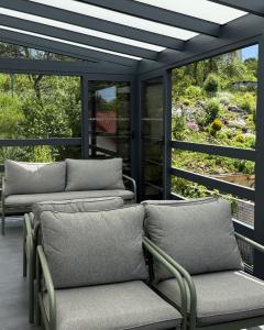 a screened porch with four chairs and windows at IQ Apartments in Prešov