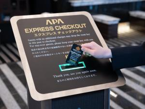 a person holding a sign with a hand on it at APA Hotel Roppongi Ekimae in Tokyo