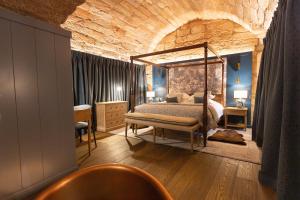 a bedroom with a canopy bed in a brick wall at Dalhousie Castle in Bonnyrigg +161 photos